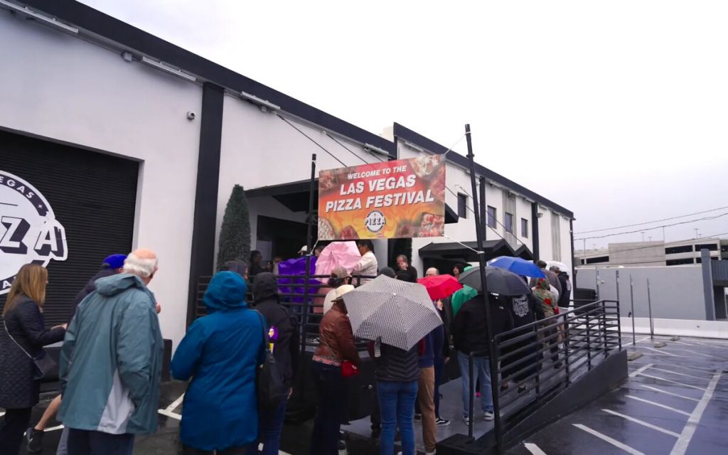 Guests arriving for the rainy 2025 Las Vegas Pizza Festival at The INDUSTRIAL Event Space
